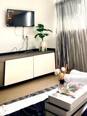 a living room with a white cabinet and a table at Impact Arena C75fl by GoodRoom24 in Ban Song Hong