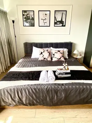 a bedroom with a bed with slippers on it at Impact Arena C75fl by GoodRoom24 in Ban Song Hong