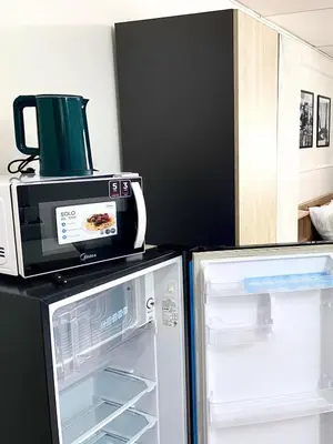 a microwave sitting on top of a refrigerator at Impact Arena Condo C7 fl12 By GoodRoom24 in Ban Song Hong