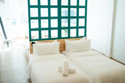 two beds sitting next to each other in a room at The companions house in Sathani Bang Su