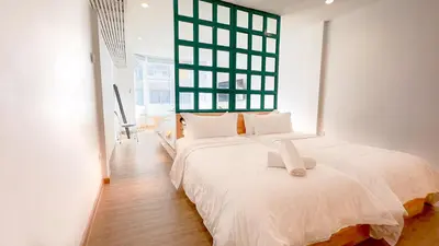 a bedroom with two beds and a large window at The companions house in Sathani Bang Su