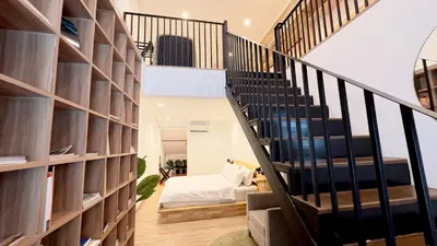 a room with a staircase with a book shelf at The companions house in Sathani Bang Su