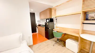 a small room with a bed and a kitchen at The companions house in Sathani Bang Su