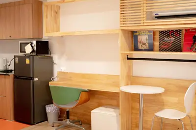 a kitchen with a refrigerator and a table and chairs at The companions house in Sathani Bang Su