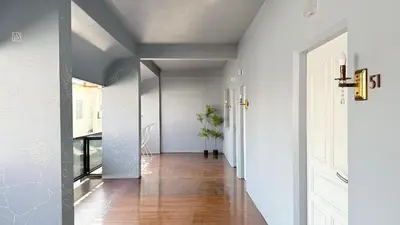 a hallway of a home with white walls and wood floors at Issara House Bangkok in Bangkok