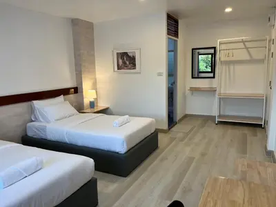 a hotel room with two beds and a table at Silpasala StayZ in Sathani Ban Hua Mak
