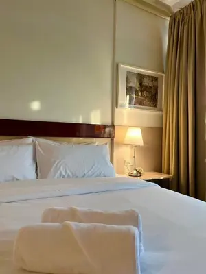 a bedroom with a large white bed with a lamp at Silpasala StayZ in Sathani Ban Hua Mak