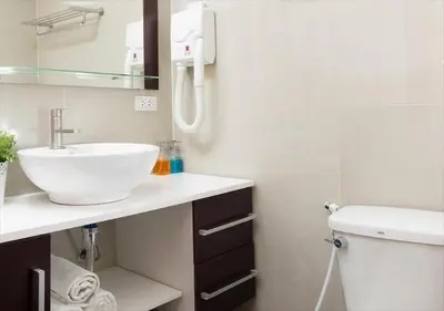 a white bathroom with a sink and a toilet at Ratchada Point Hotel in Bangkok