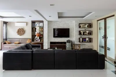 a living room with a black leather couch at Modern Home in Sukhumvit in Bangkok
