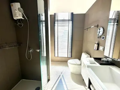 a bathroom with a toilet and a sink and a shower at Spacious Serviced Apartment! in Bangkok