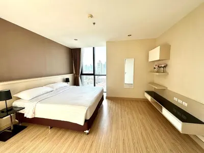 a bedroom with a large bed and a large window at Spacious Serviced Apartment! in Bangkok