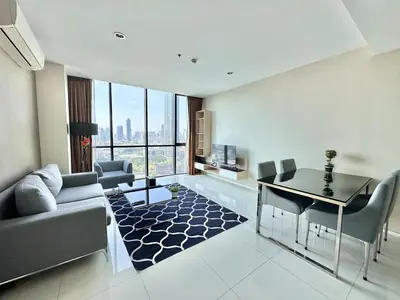 a living room with a couch and a table and chairs at Spacious Serviced Apartment! in Bangkok