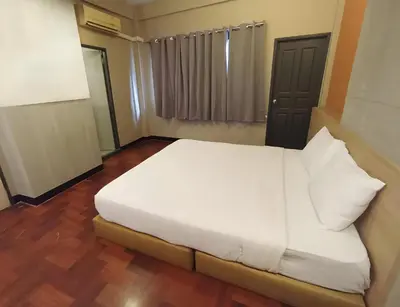 a bedroom with a white bed with white pillows at XX GO INN BTS Silom - Saint Louis สถานีรถไฟฟ้าเซนต์หลุยส์ in Bangkok
