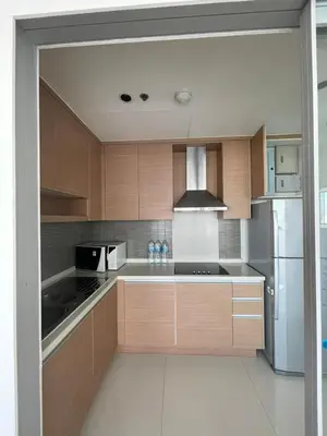 a kitchen with wooden cabinets and a stainless steel refrigerator at The Emporio Place in Bangkok
