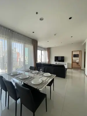 a dining room with a table and chairs and a couch at The Emporio Place in Bangkok