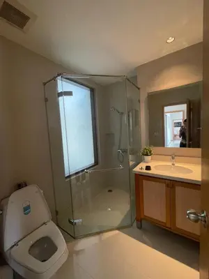 a bathroom with a shower and a toilet and a sink at The Emporio Place in Bangkok