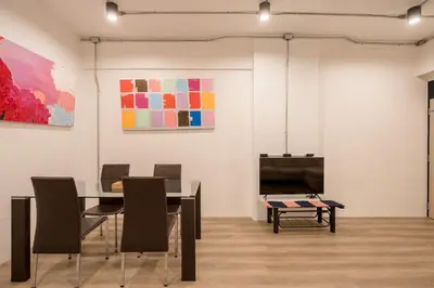 a dining room with a table and paintings on the wall at Silom Condominium in Bang Rak