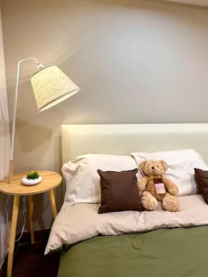 a teddy bear sitting on a bed next to a lamp at D Glamor Hotel Phutthamonthon Sai 1 ,Southern Bus Terminal, Bangkok in Bangkok