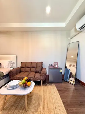 a living room with a couch and a table with a bowl of fruit at D Glamor Hotel Phutthamonthon Sai 1 ,Southern Bus Terminal, Bangkok in Bangkok