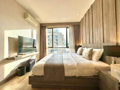 a bedroom with a large bed and a large window at Cozy & Bright apartment - Asoke in Bangkok