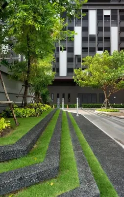 a road in front of a building with trees and grass at 1 Bedroom Condo Pool Gym BTS Cowork Sky in Godown