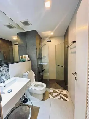 a bathroom with a toilet and a sink and a shower at 1 Bedroom Condo Pool Gym BTS Cowork Sky in Godown