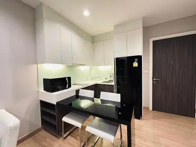 a kitchen with a desk with chairs and a microwave at 1 Bedroom Condo Pool Gym BTS Cowork Sky in Godown