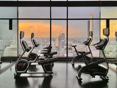a gym with rows of cardio equipment in a large window at 1 Bedroom Condo Pool Gym BTS Cowork Sky in Godown