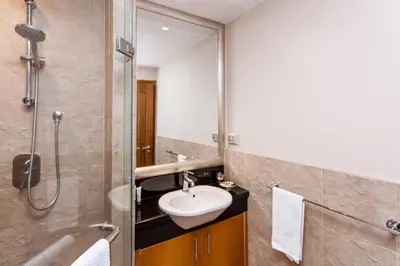 a bathroom with a sink and a shower at SkyVillas Residential Apartments in Yan Nawa
