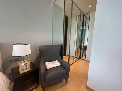 a bedroom with a chair and a lamp and a mirror at Luxury Apartment Best Location Silom in Bangkok