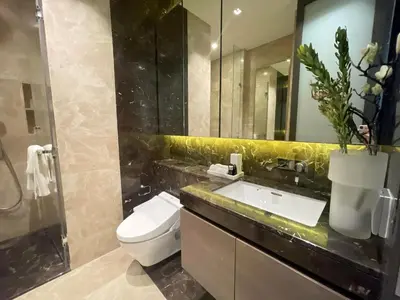 a bathroom with a toilet and a sink and a mirror at Luxury Apartment Best Location Silom in Bangkok