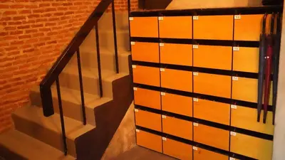 a wooden chest of drawers next to a staircase at Stay At pan Hostel in Bangkok