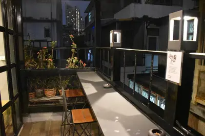 a balcony with chairs and plants on a building at Stay At pan Hostel in Bangkok
