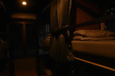a dark room with a group of bunk beds at Stay At pan Hostel in Bangkok