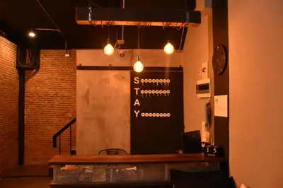 a restaurant with a sign on a wall with lights at Stay At pan Hostel in Bangkok