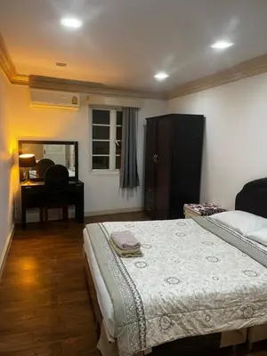 a bedroom with a bed and a desk with a chair at Euro Classic Condominium in Bangkok