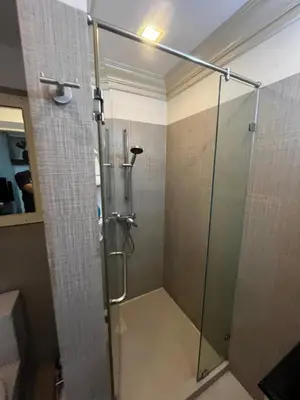 a shower with a glass door in a bathroom at Euro Classic Condominium in Bangkok