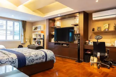 a bedroom with a bed and a flat screen tv at Luxury 4 KingSize BedRooms - Central & Modern Sukhumvit in Bangkok