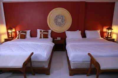 two beds in a room with red walls at UPAR Hotels Silom in Bangkok