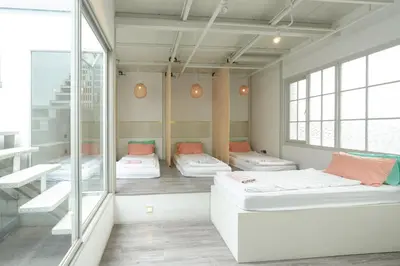 a room with three beds and a window at The Local Khaosan Bangkok Hotel in Bangkok