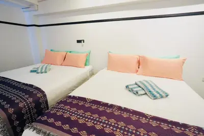 two beds sitting next to each other in a room at The Local Khaosan Bangkok Hotel in Bangkok