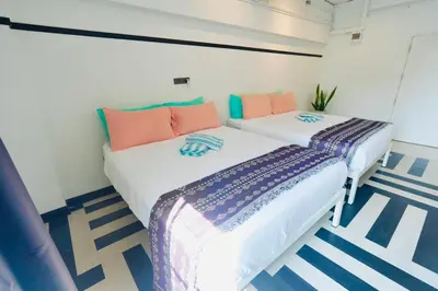 two beds in a room with blue and white at The Local Khaosan Bangkok Hotel in Bangkok