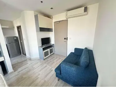 a living room with a blue couch and a television at Ideo Mobi Condo in Bangkok