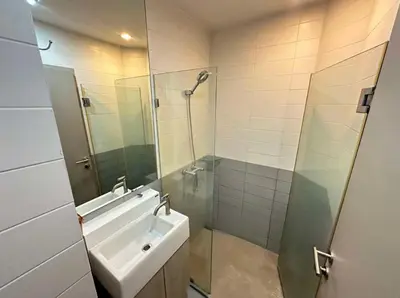 a bathroom with a glass shower and a sink at Ideo Mobi Condo in Bangkok