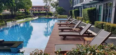 a pool with lounge chairs next to a building at Ideo Mobi Condo in Bangkok