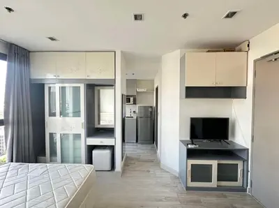 a bedroom with a bed and a desk with a television at Ideo Mobi Condo in Bangkok