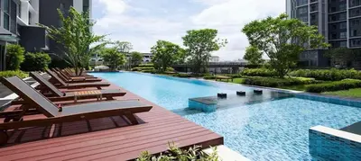 a large swimming pool with lounge chairs on a building at Ideo Mobi Condo in Bangkok
