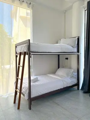 two bunk beds in a room with a window at Shared Room Megun in Ban Bang Phlat