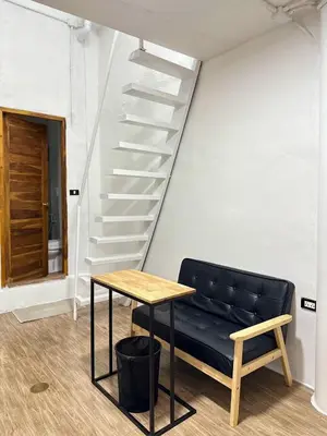 a bench and a table in a room with stairs at Megun Room5 in Ban Bang Phlat