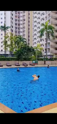 a group of people swimming in a large swimming pool at River View Active 02 in Bangkok